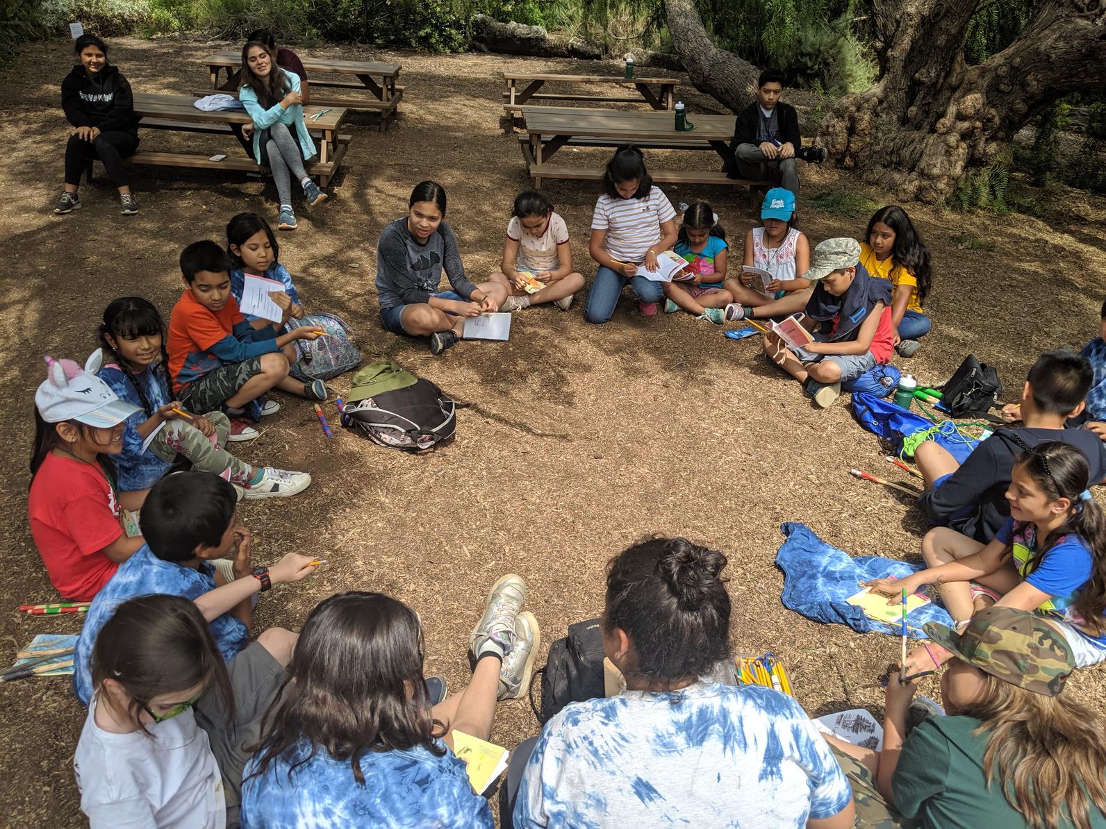 Summer campers gather in a circle at the end of the day to recap what they learned that day.