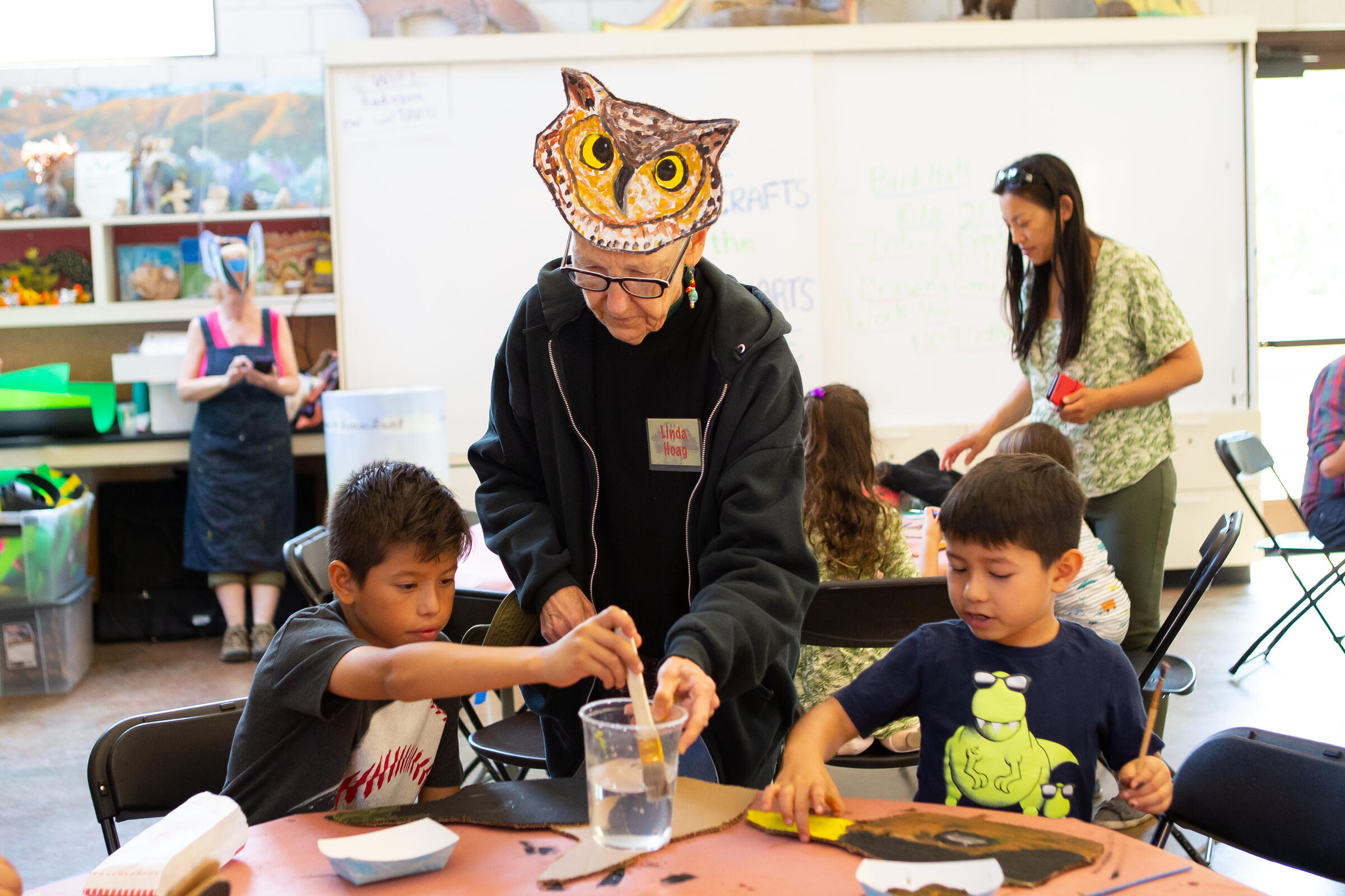 Member of Arroyo Arts Collective helps kids create bird hats in celebration of the Bird LA Day Festival.